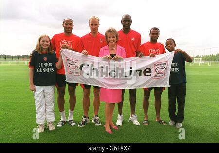 Arsenal-Spieler (von links nach rechts) Thierry Henry, Dennis Bergkamp, Patrick Vieira und Ashley Cole mit TV-Moderatorin und Childline-Vorsitzende Esther Rantzen (Mitte), die während der Eröffnung der ersten Partnerschaft des Arsenal Football Club „Charity of the Season“ auf dem Arsenal-Trainingsgelände in London Colney, Hertfordshire, ein Childline-Banner mit einem Die neue Initiative soll das Bewusstsein für und die dringend benötigten Mittel für eine engagierte Wohltätigkeitsorganisation pro Saison schärfen. Rantzen sagte: „Wir freuen uns sehr, dass wir zum ersten „Charity of the Season“ von Arsenal gewählt wurden und freuen uns auf eine erfolgreiche Partnerschaft. Stockfoto