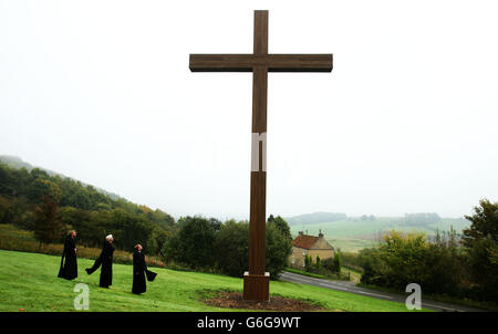 (Von links nach rechts) Pater Gordon, Pater Matthew und Pater Luke untersuchen den Abschluss der Arbeiten am Millennium-Kreuz in Ampleforth Abbey and College, North Yorkshire. Das Kreuz, das zu seiner imposanten Bestform restauriert wurde, steht in einer der schönsten Gegenden von North Yorkshire und ist 1,50 m hoch und 1,50 m breit. Stockfoto