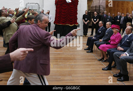 Königin Elizabeth II. Sehen Sie sich in Begleitung des Herzogs von Edinburgh während eines Besuchs im National Theatre in London eine Aufführung eines Liedes aus dem Musical „Guys and Dolls“ an, um an den 50. Jahrestag der Institution zu erinnern. Stockfoto