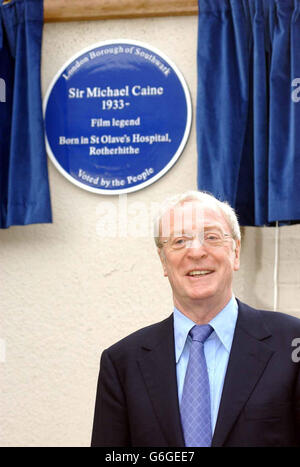 Die Hollywood-Legende Sir Michael Caine steht unter der von ihm enthüllten Gedenktafel zu seinem Geburtsort am Standort des ehemaligen St. Olave's Hospital in Rotherhithe, im Südosten Londons. Sir Michael - der Star klassischer britischer Filme wie Alfie, Get Carter und The Ital Job - erzählte, wie er 30 Minuten zu Beginn der Enthüllungszeremonie ankam, damit er durch sein altes Viertel fahren und staunen konnte, wie "großartig" die Gegend aussah. Der Hollywood-Star war einer von 20 Menschen, die von der Öffentlichkeit im Rahmen des Blue Plaque-Projekts des Southwark Council, das vom englischen Heritage Scheme getrennt ist, gewählt wurden. Stockfoto