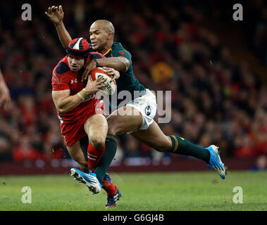 Der walisische Leigh Halfpenny wird vom südafrikanischen JP Pietersen während des Spiels der Dove Men Series im Millennium Stadium in Cardiff angegangen. Stockfoto