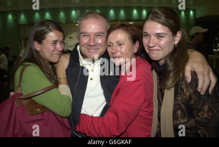 Der britische Geschäftsmann George Atkinson mit seiner Frau Helene und den Töchtern Nina (links) und Alice (rechts) kommt am Montag, den 1. September 2003, am Flughafen Heathrow an, nachdem er sechs Jahre lang in einem Gefängnis in Dubai festgehalten wurde, weil er angeblich die Regierung um Millionen Pfund betrogen hatte. Atkinson, 51, aus Rockbourne, in der Nähe von Fordingbridge, Hampshire, Wurde in Dubai um 13.30 Uhr Ortszeit (10.30 Uhr MEK) aus der Haft entlassen und sofort deportiert. Im Dezember 1998 wurde er zu einer Geldstrafe von 1.3 Millionen Dollar verurteilt und zu sechs Jahren Gefängnis verurteilt. Er hat immer gegen seine Unschuld protestiert. Stockfoto