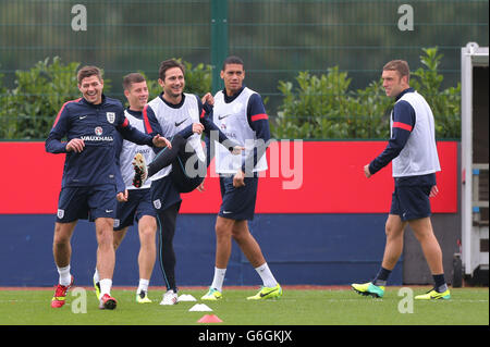 Steven Gerrard aus England teilt einen Witz, als er die Spieler im Warm-Up mit Frank Lampard, Ross Barkley, Chris Smalling, Ricky Lambert und (rechts) während des Trainings in London Colney, Hertfordshire, anführt. Stockfoto