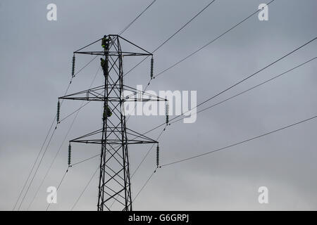 Strommonnenlager. Arbeiter klettern auf einen Strommast, um Wartungsarbeiten in Monkspath, Solihull, West Midlands, durchzuführen. Stockfoto