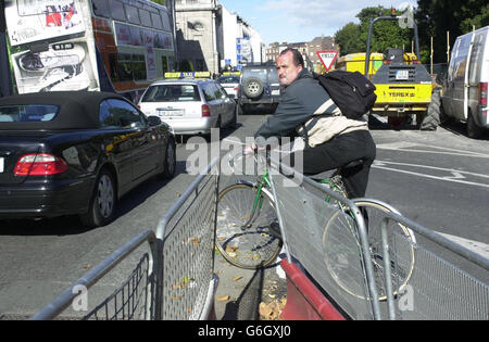 Ein Radfahrer wartet auf eine Lücke, die im starken Verkehr am Luas-Werk neben St. Stephen's Green, Dublin, am Europäischen autofreien Tag erscheinen wird. Die Fahrgäste fuhren heute kostenlos mit den Bussen der Irischen Republik, um den Verkehrsstau in den städtischen Zentren zu verringern. In 17 irischen Städten und Städten wurde ein autofreier Tag markiert, an dem Passagiere zwischen 10 und 16 Uhr kostenlos reisen können. Dublin Bus bot die kostenlose Nutzung seiner Dienste von 10 bis 13 Uhr an, um den Fahrgästen die Vorteile des Abfahrens ihres Autos zu Hause zu zeigen. Stockfoto