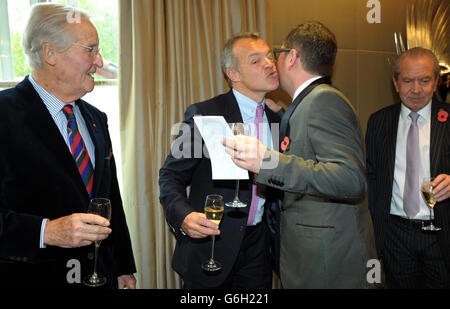 Ehrengast Graham Norton begrüßt Alan Carr, während Nichola Parsons (links) und Lord Alan Sugar (rechts) bei einem Tribute Lunch, das von den Lady Taverners im Dorchester Hotel, London, veranstaltet wird. Stockfoto