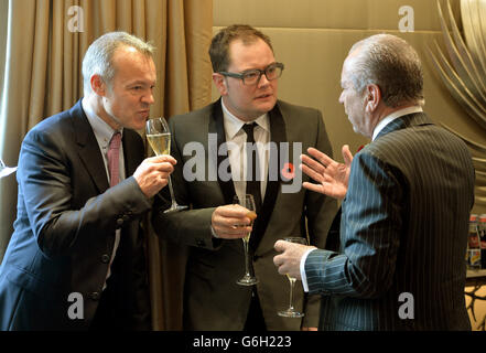 Ehrengast Graham Norton (links) spricht mit Alan Carr (Mitte) und Lord Alan Sugar während eines Tribute-Mittagessens, das von den Lady Taverners im Dorchester Hotel, London, veranstaltet wird. Stockfoto