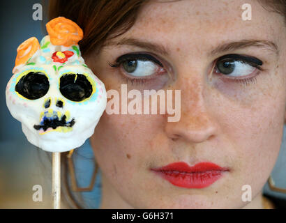 Greer Pester aus Glasgow hält einen Zuckerschädel, während sie ihrer verstorbenen Tante Jacqueline Pester bei einem Schreinmachworkshop in der Gallery of Modern Art in Glasgow im Rahmen des First Day of the Dead Festivals in Schottland einen Schrein macht. Stockfoto