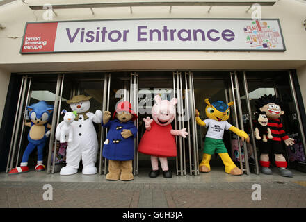 Charakter und Maskottchen (von links nach rechts) Sonic the Hedgehog, the Snowman with Snowdog, Paddington Bear, Peppa Pig, Fuleco (FIFA World Cup 2014 Mascot) und Dennis the Bedroace, auf der Brand Licensing Europe Ausstellung, in Olympia in West London. Stockfoto