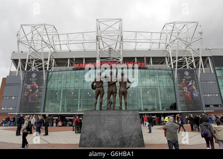 Zu sehen ist eine allgemeine Ansicht von Old Trafford, die United Trinity Statue der ehemaligen Spieler George Best, Denis Law und Bobby Charlton Stockfoto