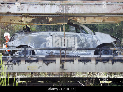 Ausgebrannte Autos werden in den Nebengleisen des Bahnhofs Oxenholme bei Kendal inspiziert. Hunderte von Bahnreisenden mussten Verspätungen und Annullierungen hinnehmen, nachdem ein Güterzug mit Kraftfahrzeugen auf einer Hauptlinie von London nach Schottland Feuer fing. Ein Sleeper-Zug nach London kam drei Stunden zu spät an und ein anderer hatte fast zwei Stunden Verspätung. Die West Coast Main Line wurde für mehrere Stunden geschlossen und eine Reihe von ersten nordwestlichen Zügen wurden abgesagt. Das Feuer brannte auf einem EWS-Güterzug, der Citroen- und Peugeot-Autos von Washwood Heath in der Nähe von Birmingham nach Bathgate in West Lothian, Schottland, nahm. Stockfoto