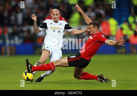 Jonjo Shelvey von Swansea City wird von Ben Turner von Cardiff City während des Spiels der Barclays Premier League im Cardiff City Stadium in Cardiff angegangen. Stockfoto