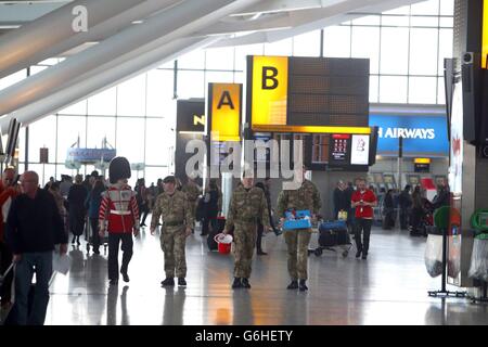 Soldaten, die am Londoner Mohn-Tag der Royal British Legion (RBL) im Terminal 5 am Flughafen Heathrow in London Mohnblumen verkaufen. Stockfoto