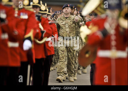 Ein marschierende Soldat zwischen Mitgliedern der Regimentsgruppe, die die Medaillenparade führen, marschiert auf den Paradeplatz für Soldaten, die in Afghanistan bei der Operation HERRICK dienten 18 von 6 Close Support Bataillon die Parade der königlichen Elektro- und Maschineningenieure im Tidworth-Lager. Stockfoto