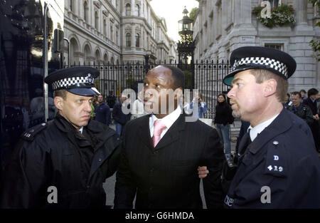 Chris Eubank, der von der Polizei vor der Downing Street im Zentrum Londons weggeführt wurde, nachdem er an einem ein-Mann-Protest gegen die militärische Besetzung des Irak teilgenommen hatte. Der extravagante Showman setzte seinen riesigen Lastwagen vor der Downing Street zurück und klangte für etwa eine Minute sein Horn. Er fuhr dann vor der Rückkehr für ein zweites Mal, aber wurde prompt weggenommen, nachdem er in einen Lieferwagen umkehrte und wieder sein Horn erklang. Stockfoto