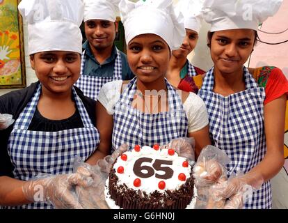 Eine Gruppe von Studenten mit einem Geburtstagskuchen, der am dritten Tag ihrer elftägigen Reise durch Indien und Sri Lanka für den 65. Geburtstag des Prinzen von Wales in der nächsten Woche in der Katha School in Delhi, der Hauptstadt Indiens, gemacht wurde. Stockfoto