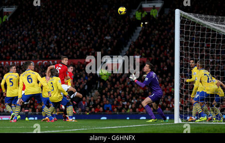 Robin van Persie von Manchester United (Mitte versteckt) erzielt ihr erstes Tor des Spiels mit einem Kopfball während des Barclays Premier League-Spiels in Old Trafford, Manchester. Stockfoto