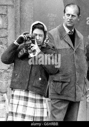 Die Königin, die vom Herzog von Edinburgh beobachtet wird, fotografiert ihr Pferd columbus mit einer vergoldeten Kamera bei der Veterinäruntersuchung am ersten Tag der Badminton-Pferdeprüfung 1974. Stockfoto