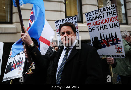 Nick Griffin, Vorsitzender der British National Party, schließt sich vor einer Gerichtsverhandlung gegen Michael Adebolajo (28) und Michael Adebowale (22), die wegen des Mordes an Schlagzeuger Lee Rigby angeklagt sind, Mitgliedern der British Veterans' Group außerhalb des Old Bailey in London an. Stockfoto