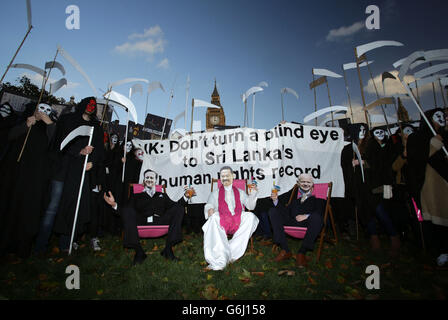 Amnesty-Anhänger als grimmige Schnitter gekleidet, versammeln sich David Cameron, der Präsident Sri Lankas Mahinda Rajapaksa und Außenminister William Hague auf dem Parliament Square im Zentrum von London, um gegen die Unterstützung Sri Lankas durch die britische Regierung beim bevorstehenden Commonwealth Heads of Government Meeting (CHOGM) in Colombo zu protestieren. Stockfoto