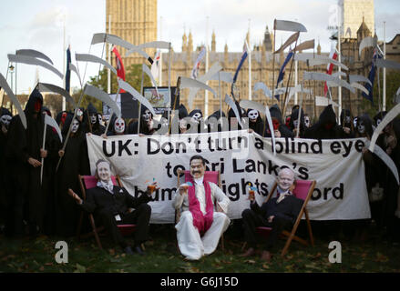 Amnesty-Anhänger als grimmige Schnitter gekleidet, versammeln sich David Cameron, der Präsident Sri Lankas Mahinda Rajapaksa und Außenminister William Hague auf dem Parliament Square im Zentrum von London, um gegen die Unterstützung Sri Lankas durch die britische Regierung beim bevorstehenden Commonwealth Heads of Government Meeting (CHOGM) in Colombo zu protestieren. Stockfoto