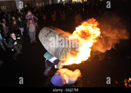 Erwachsene aus dem Dorf Ottery St Mary in Devonshire tragen das traditionelle Tar Barrel in der Bonfire Night durch die Straßen des Dorfes. Stockfoto