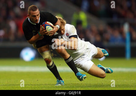 Rugby Union - QBE International - England / Neuseeland - Twickenham. Der Neuseeländer Aaron Cruden wird von Englands Billy Twelvetrees während der QBE International im Twickenham Stadium, London, angegangen. Stockfoto