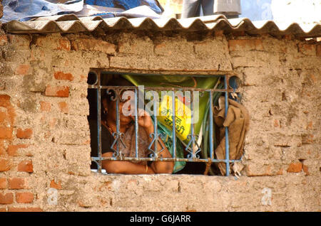 Ein Bewohner der Slums von Dharavi wartet auf die Ankunft des Prinzen von Wales während seines Besuchs am Stadtrand von Bombay, Indien. Charles, der gestern die hellen Lichter der Bollywood-Filmwelt genoss, machte sich auf die Reise, um die riesigen, in Schichtführung erbauten Wohnungen der Stadt zu sehen. Stockfoto