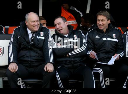 Fußball - Barclays Premier League - Fulham gegen Swansea City - Craven Cottage. Fulham-Manager Martin Jol (links) spricht mit seinem Cheftrainer Rene Meulensteen (Mitte) und Michael Lindeman im Dugout Stockfoto