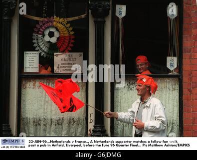 22-JUN-96. Niederlande – Frankreich. Ein niederländischer Unterstützer sieht einem anderen Fan vor dem Finale der EM 96 an einem Pub in Anfield, Liverpool, vorbeilaufen Stockfoto