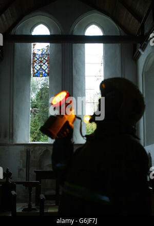 Ein Feuerwehrmann inspiziert das Kirchenschiff der St. Andrew's Church in Tangmere, West Sussex, nachdem ein Blitz die Turmspitze des Gebäudes aus dem 12. Jahrhundert in der Nähe von Chichester getroffen hatte, als Gewitter den Süden Englands heimgesucht hatten. Der Blitz hinterließ ein klaffendes Loch, nachdem er gegen Mittag auf den Kirchturm der St. Andrew's Church traf und alle außer einem seiner Buntglasfenster ausblasen konnte. Stockfoto