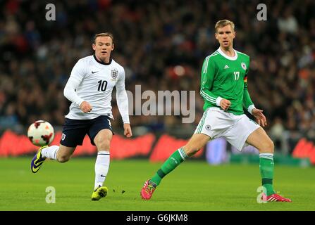 Fußball - International freundlich - England gegen Deutschland - Wembley Stadium. Der englische Wayne Rooney (links) und der deutsche per Mertesacker in Aktion Stockfoto