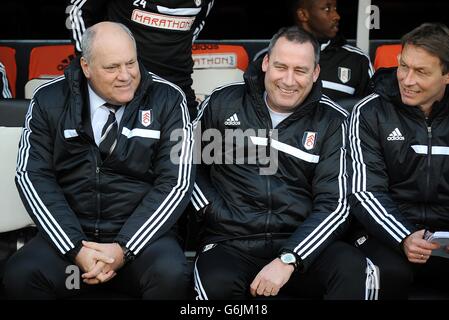 Fulham-Manager Martin Jol (links) spricht mit seinem Cheftrainer Rene Meulensteen (Mitte) und Michael Lindeman im Dugout Stockfoto