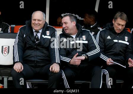 Fulham-Manager Martin Jol (links) spricht mit seinem Cheftrainer Rene Meulensteen (Mitte) und Michael Lindeman im Dugout Stockfoto