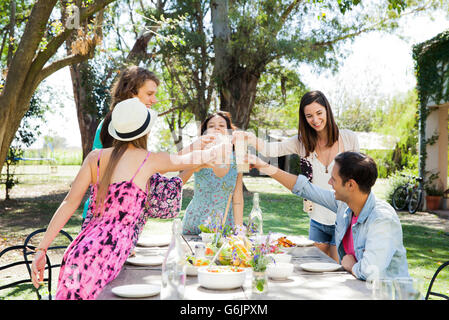 Freunde, die zusammen mit der Mahlzeit im freien feiern Stockfoto