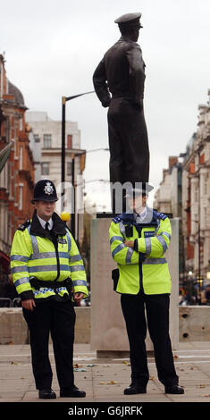 Vor dem Staatsbesuch des amerikanischen Präsidenten George Bush stehen einige Polizisten im Schatten einer Statue des ehemaligen US-Präsidenten Dwight D Eisenhower in der Nähe der amerikanischen Botschaft im Zentrum von London. Die größte Sicherheitsoperation, die jemals in Großbritannien für einen Besuch des Staatsoberhauptes durchgeführt wurde, bereitet sich vor der umstrittenen Ankunft von Präsident Bush heute Abend in London auf. Stockfoto