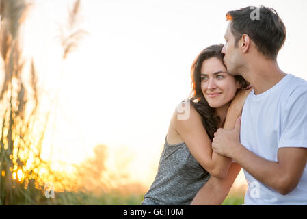 Mann küssen Freundin Stirn Stockfoto