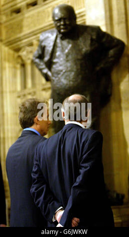 Premierminister Tony Blair und der Oppositionsführer Michael Howard gehen nach der Eröffnung des Londoner Parlaments an einer Statue von Winston Chaurchill vorbei. Die britische Königin Elizabeth II., die im Oberhaus auf dem Thron sitzt, kündigte formell das Gesetzgebungsprogramm der britischen Regierung für die neue Parlamentssitzung an. Stockfoto