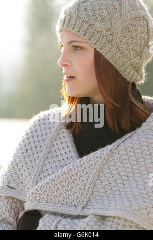 Junge Frau trägt eine Strickjacke und eine Wollmütze Stockfoto