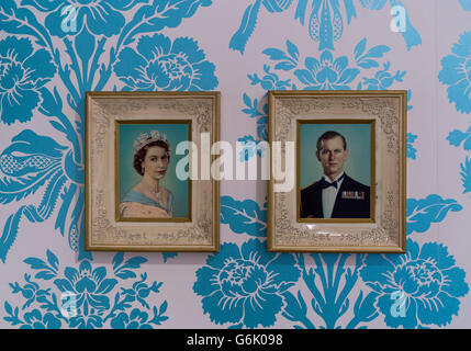 Bilder von Queen Elizabeth II und Prinz Philip auf Wand mit floral Tapete, Stuttgart Stockfoto