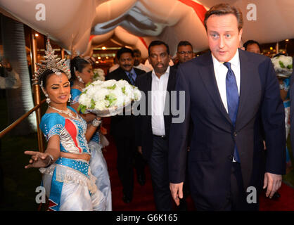 Premierminister David Cameron wird von traditionellen srilankischen Tänzern begrüßt, als er zum Beginn des von Sri Lanka ausgerichteten Commonwealth-Treffen der Regierungschefs in Colombo eintrifft. Stockfoto