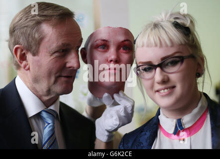 Taoiseach Enda Kenny posiert mit dem Studenten Ling Heaney und einer Maske, während er das Programm von vier neuen Ausstellungen für 2014 in der Science Gallery am Trinity College startet. Die Maske wurde mit Spuren menschlicher DNA erstellt, die auf Zigarettenkippen in den Straßen Dublins gefunden wurden und in ein Labor gebracht und eine DNA-Extraktion durchgeführt wurde. Bestimmte Regionen der DNA wurden mit einer Technik namens PCR - Polymerase-Kettenreaktion amplifiziert. Dies ermöglicht es, bestimmte Regionen des Genoms zu untersuchen, die dazu neigen, von Person zu Person zu variieren, die als Single Nucleotid Polymorphisms (SNP) bekannt sind. Stockfoto