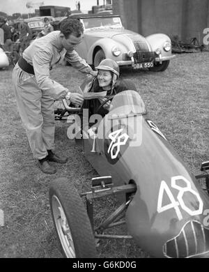 Lächelnd FAY TAYLOUR, gerade von Rennen in Schweden und zuvor in den Vereinigten Staaten zurückgekehrt, zeigt STIRLING MOOS ein Telegramm, das sie gerade erhalten hatte und lädt sie ein, an zwölf Treffen in Sydney, Australien, teilzunehmen. Sie nahm am nationalen Autorennen-Treffen in Castle Combe, Wiltshire, Teil und war die einzige weibliche Fahrerin des Tages. Stockfoto