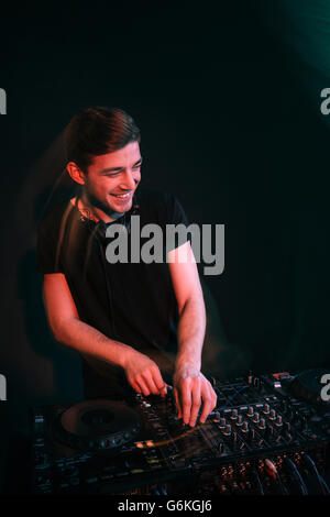 Glücklich hübscher Junge dj stehend und Musizieren auf schwarzem Hintergrund Stockfoto