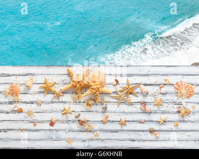 Alte weiße Holz mit Muscheln drauf.  Gegen blaue Meer. Stockfoto