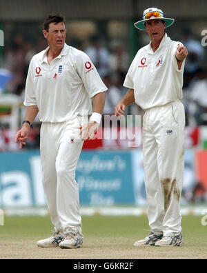 England Kapitän Michael Vaughan (rechts) hat ein Wort mit der Spinnerin Ashley Giles, am vierten Tag des ersten Testkampfes gegen Sri Lanka im Galle International Stadium. Ein Regenguss führte zu einem frühen Mittagessen, mit Sri Lanka in ihren zweiten Innings 157 für 6 - ein Vorsprung von 253 über die Touristen. Stockfoto