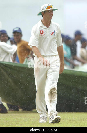 England-Kapitän Michael Vaughan (rechts) geht nach einem Regenguss, der eine frühe Mittagspause erzwang, am vierten Tag des ersten Testspieles gegen Sri Lanka im Galle International Stadium vom Spielfeld. Sri Lanka in ihren zweiten Innings waren 157 für 6 - ein Vorsprung von 253 über die Touristen, als der Regen das Spiel unterbrach. Stockfoto