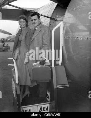 George Cole und seine Braut Eileen Moore stellten sich vor, als sie auf dem Londoner Flughafen für ihre Flitterwochen in Paris in ein BEA-Linienschiff stiegen. Das Paar, das sich traf, als beide in den Elstree-Studios drehten, heiratete heute im Hampstead Register Office, London. Stockfoto