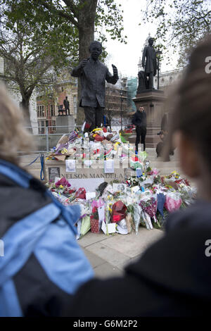 Blumen und Ehrungen neben der Nelson-Mandela-Statue am Westminster Square im Zentrum von London nach dem Tod des ehemaligen südafrikanischen Präsidenten am Donnerstagabend. Stockfoto