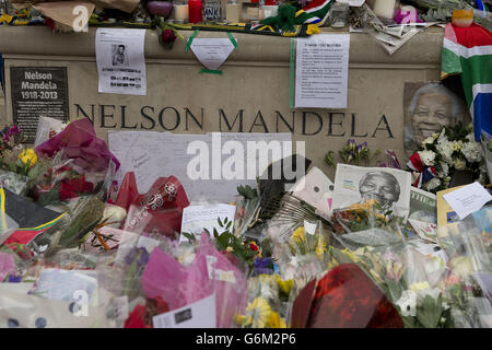 Blumen und Ehrungen neben der Nelson-Mandela-Statue am Westminster Square im Zentrum von London nach dem Tod des ehemaligen südafrikanischen Präsidenten am Donnerstagabend. Stockfoto